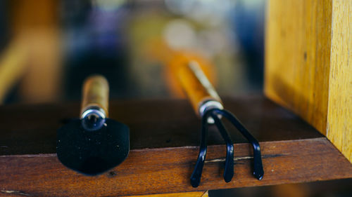 Close-up of gardening fork and trowel at window