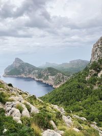 Scenic view of sea and mountains against sky