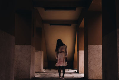 Rear view of woman walking in corridor of building