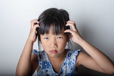 Portrait of young woman against wall
