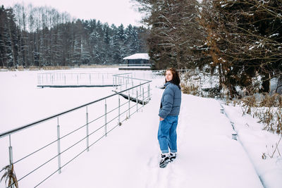 Rear view of man standing on snow covered field