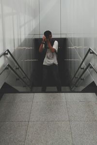 Young man standing against wall