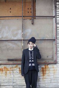 Portrait of a woman standing against the wall