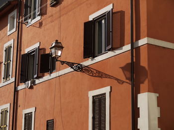 Low angle view of street light by building