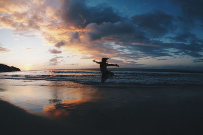 Silhouette of person jumping on beach