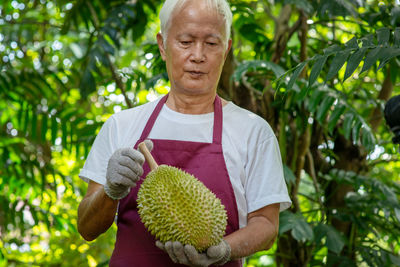 Portrait of man holding plant