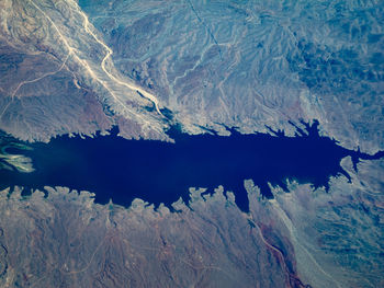 Aerial view of frozen lake by snowcapped mountain