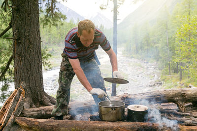 Man cooking food in forest 