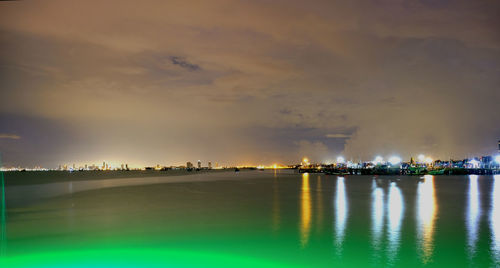 Illuminated sea against sky at night