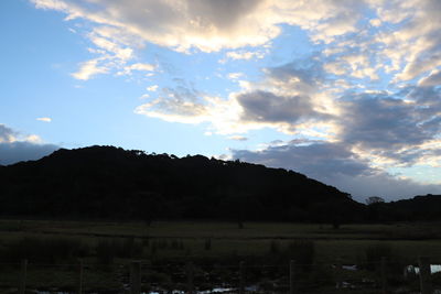 Scenic view of silhouette field against sky during sunset