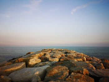 Rocks on sea shore against sky