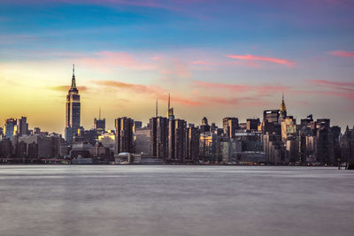 Modern cityscape against sky during sunset