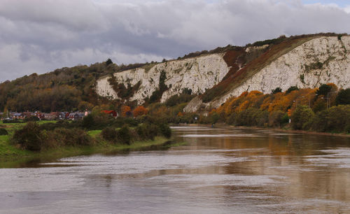 Scenic view of river by trees against sky