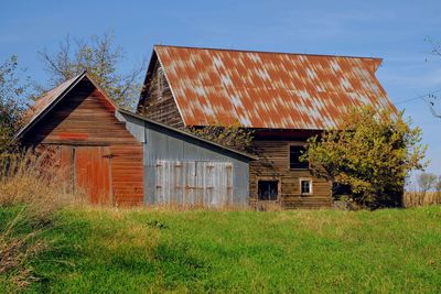 Abandoned barn on field against sky