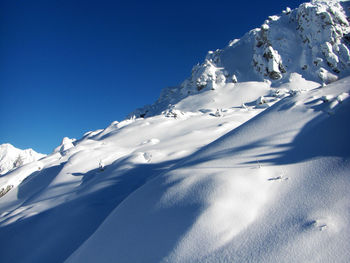 Snowcapped mountains against clear blue sky