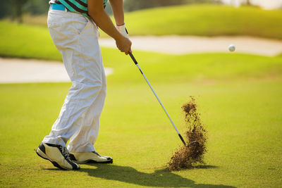 Low section of person playing golf on field