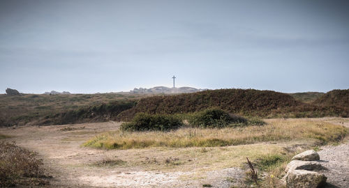 Lighthouse on field against sky