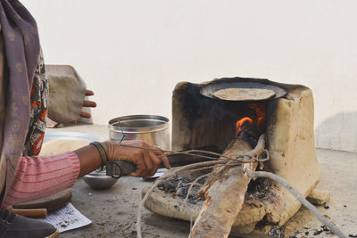 Woman cooking food on wood fire