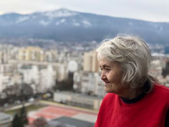 Side view of woman against city