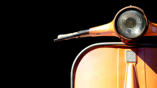 Close-up of vintage motor scooter against black background