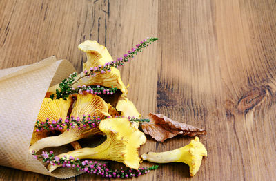 Golden chanterelle and flower on wooden table