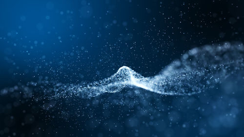 Close-up of water splashing against blue background