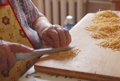 Midsection of woman chopping food on cutting board