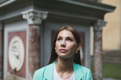 Portrait of young woman standing against the wall