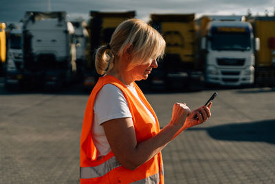 Side view of young woman using mobile phone