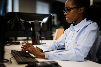 Businesswoman using laptop at desk in office