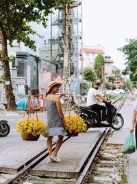 Rear view of woman sitting on street
