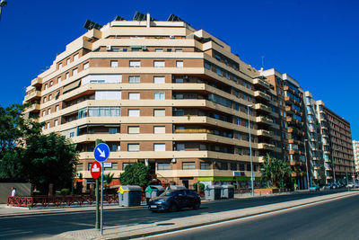 Residential building by road against clear sky