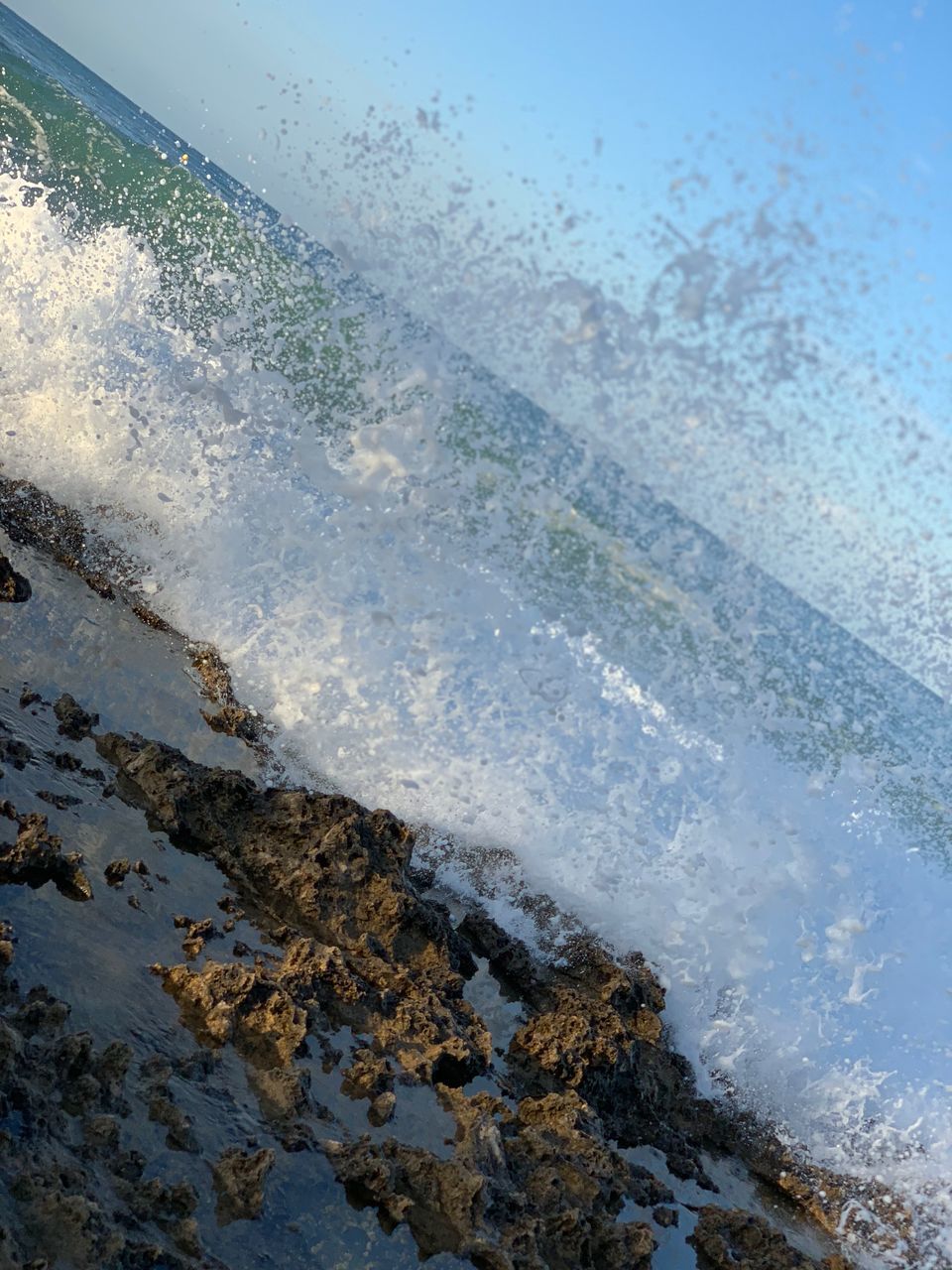 HIGH ANGLE VIEW OF WAVES SPLASHING ON BEACH