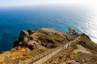 High angle view of footpath leading towards lighthouse by sea