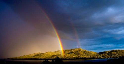 Low angle view of rainbow over mountain against sky