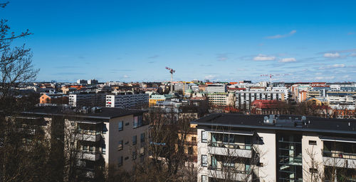 Scenic view of buildings in city against blue sky