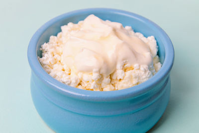 Cottage cheese in a blue bowl with sour cream and honey.