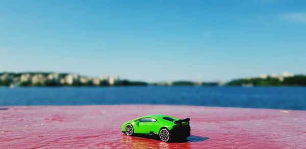 Close-up of toy car in lake against blue sky