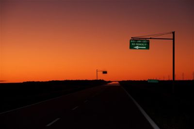 Road sign against orange sky