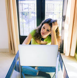 Young woman sitting on table at home