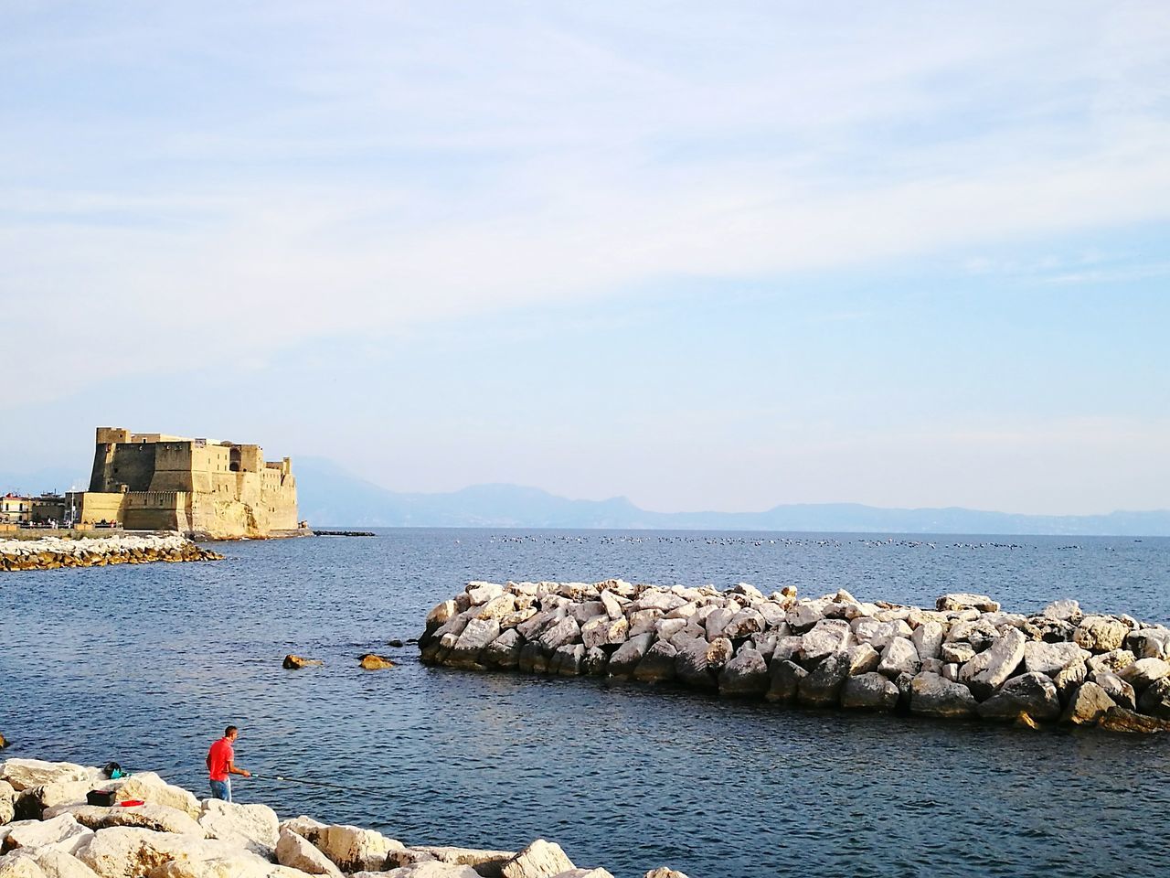 water, sea, sky, beach, building exterior, cloud, shore, vacations, tranquil scene, nature, day, tranquility, cloud - sky, outdoors, blue, summer, beauty in nature, coastline, coastal feature, tourism, cliff, distant