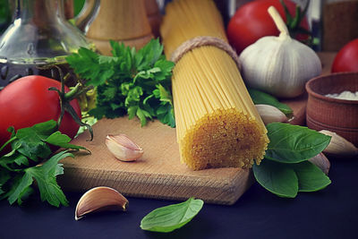 Italian healthy food table, spaghetti ,vegetables, garlic, parsley, cilantro, basil, dill, tomatoes