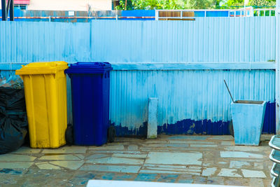 Garbage can against blue wall