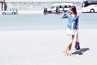 Full length of young woman using smart phone