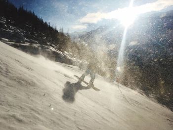 Person skiing on snow covered landscape against sky