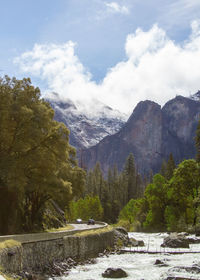 Scenic view of river by mountains against sky