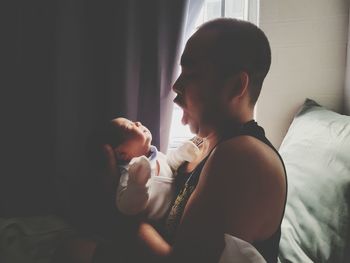 Side view of mother and daughter at home