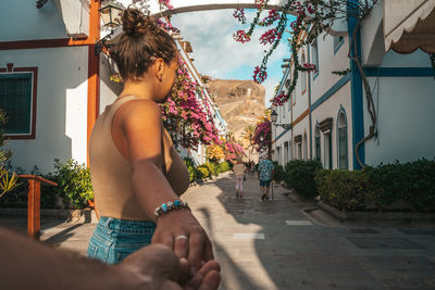 Rear view of young woman sitting on street