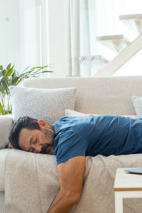 Portrait of young man sleeping on sofa at home