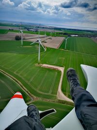 Low section of man on windmill at agricultural field